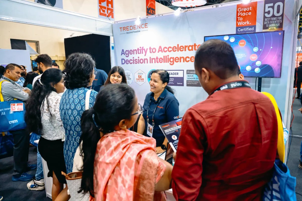 Attendees engaging at a TREDENCE booth